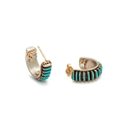 Angled view of a pair of turquoise hoops set in sterling silver.